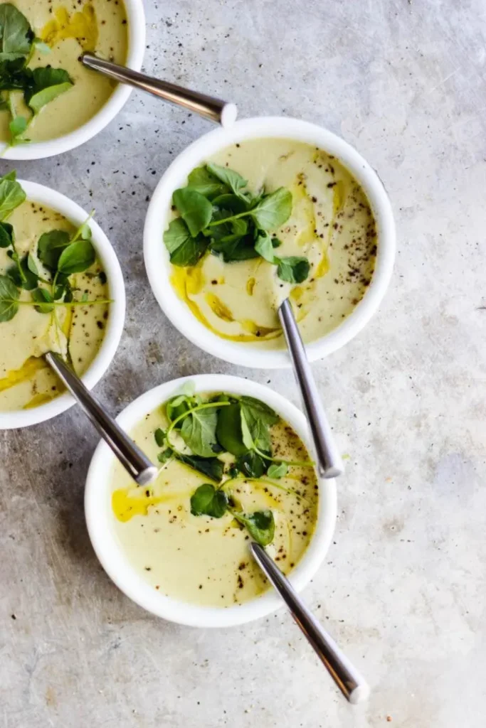 Vegan roomsoep van selderij met olijfolie en waterkers